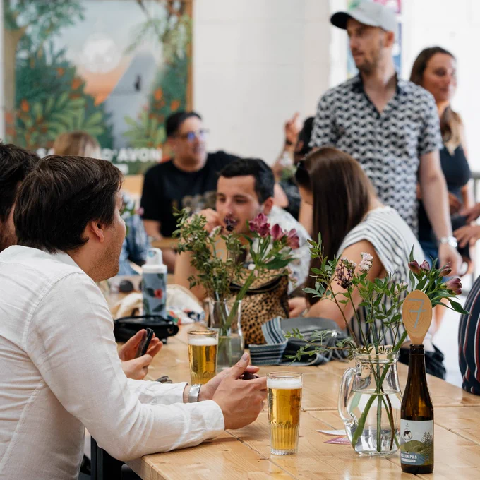 People sat together, chatting and enjoying tasty beers at the taproom