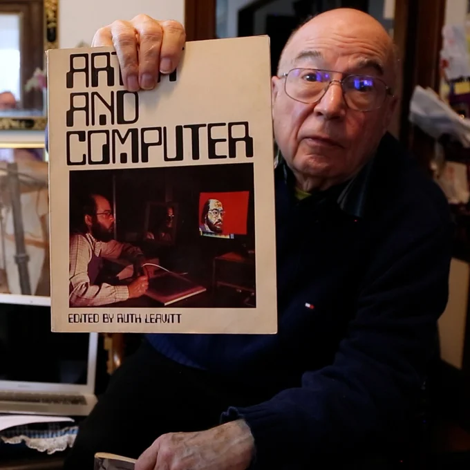 Duane Palyka holds a copy of "Artist and Computer," edited by Ruth Leavitt