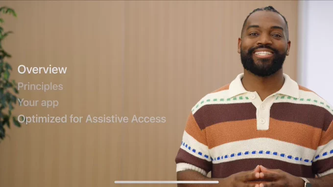Screenshot from my WWDC session “Meet Assistive Access”. I’m smiling and wearing a horizontal striped shirt with cream, dark and light brown stripes. Also in view shown is an outline of the presentation as with the sections: Overview, Principles, Your App, & Optimized for Assistive Access.