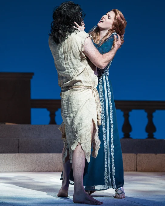 Jochanahan in tattered tunic embraced by Salome in a blue gown.