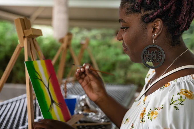 A woman paints on a canvas.