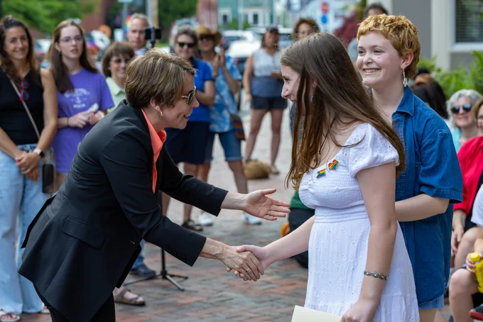 Governor Healey shaking hands with young people. 