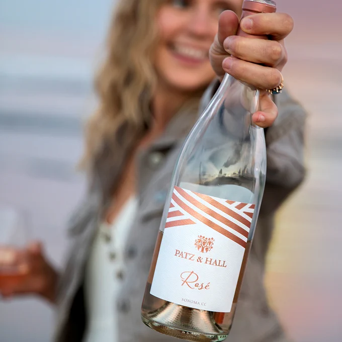 Woman holding a bottle of Patz & Hall Rosé at sunset.