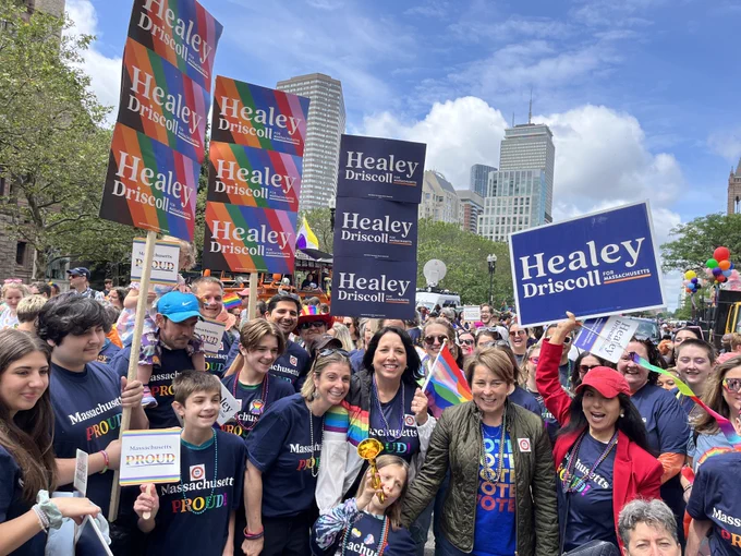 Governor Healey and Lieutenant Governor Driscoll standing with a large group of supporters holding "Healey-Driscoll" signs 