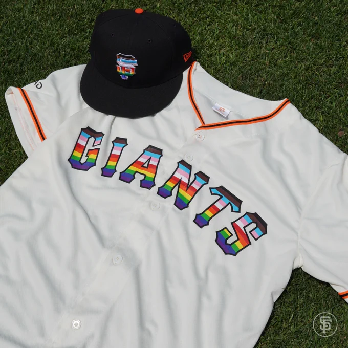 Photo of the Giants Pride Cap and Giants Pride Jersey laying in the grass.
