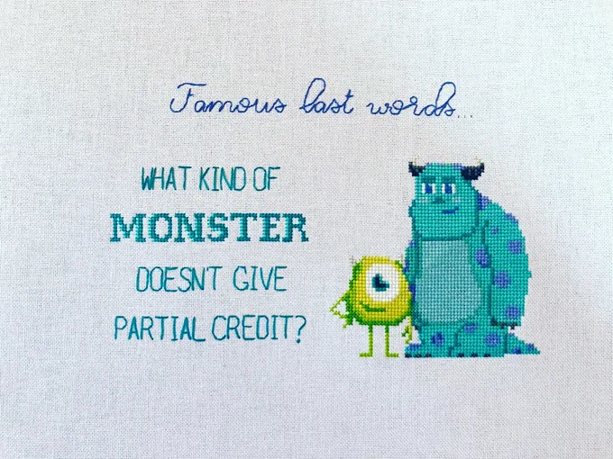 Cross stitch piece with Mike & Sully from Monsters Inc. Text: "Famous last worlds...What kind of monster doesn't give partial credit?"