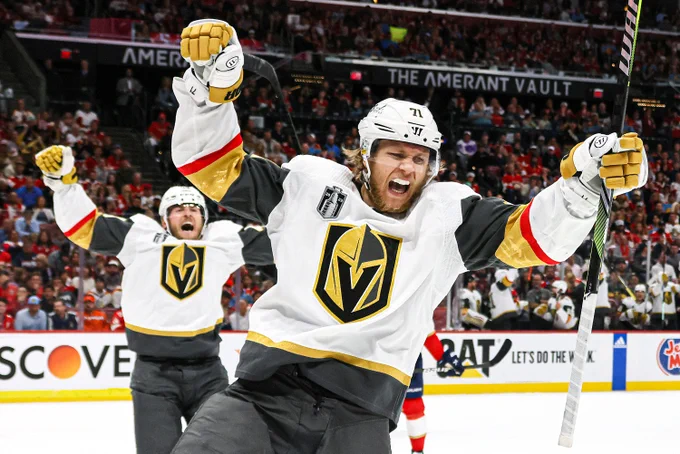 William Karlsson celebrates a goal with his arms up while yelling in celebration in a road Vegas Golden Knights uniform. 