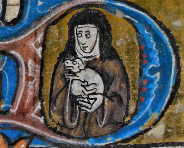 A medieval drawing of a nun inside a large letter D holding a small white dog