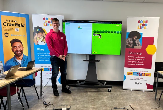 Code for Life team member in front of the teaching screen ready to teach a lesson at Eagle Lab, Cranfield.