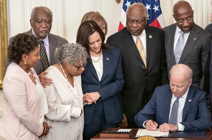 Image of President Joe Biden with Vice President Kamala Harris and lawmakers and guests, signing the Juneteenth National Independence Day Act Bill in the East Room of the White House.