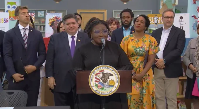 Image of ALA Executive Director Tracie D. Hall speaking at a podium at Chicago Public Library. Behind her are several Illinois officials, including Secretary of State Alexi Giannoulias, Governor J.B. Pritzker, and Lieutenant Governor Juliana Stratton.