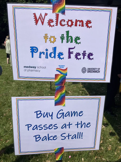 Signs with colourful writing saying Welcome to the Pride fete.