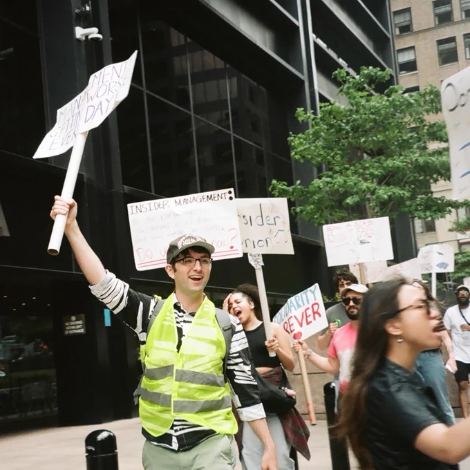 film photo of Insider employees holding picket signs outside Insider office (signs in view say Management getting worse every day, Solidarity Forever, Insider Union)