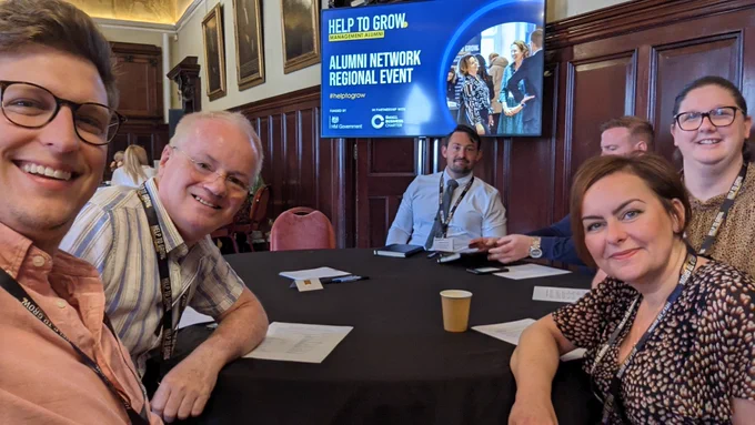 Selfie of people smiling around a table. 