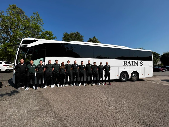 SAS charity football team outside team bus in uniform