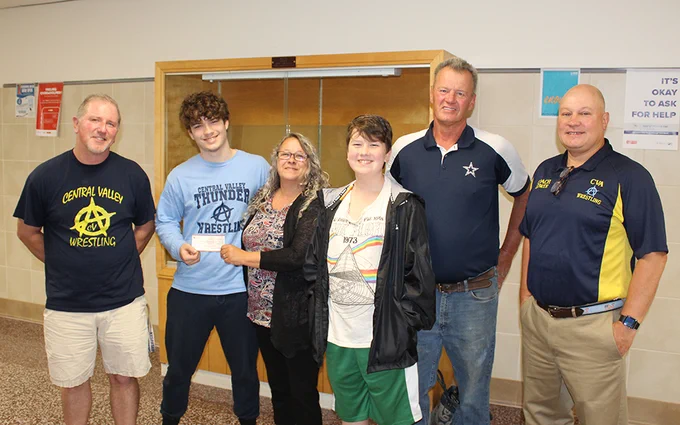5 people standing in hallway, glass trophy case