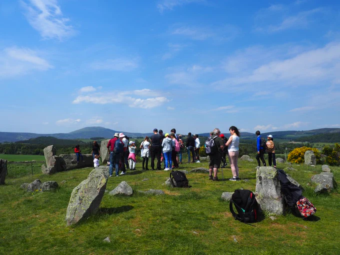 Group of people standing next to a stone circle