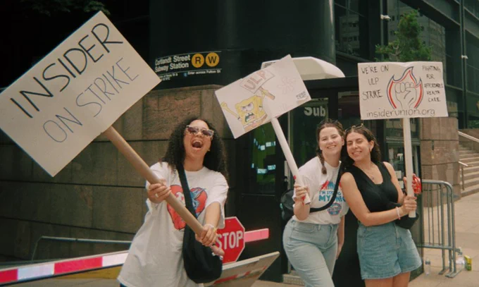 Insider Union members smiling and holding up picket signs, text in view say INSIDER ON STRIKE, WE’RE ON ULP STRIKE