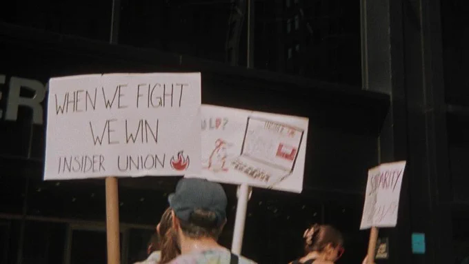 picket sign with text saying WHEN WE FIGHT WE WIN