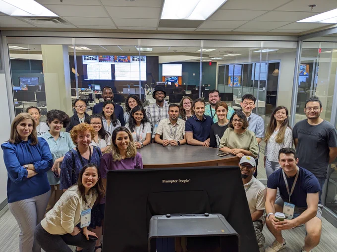 group of students in an office room gathered around a desk at the National Water Center.