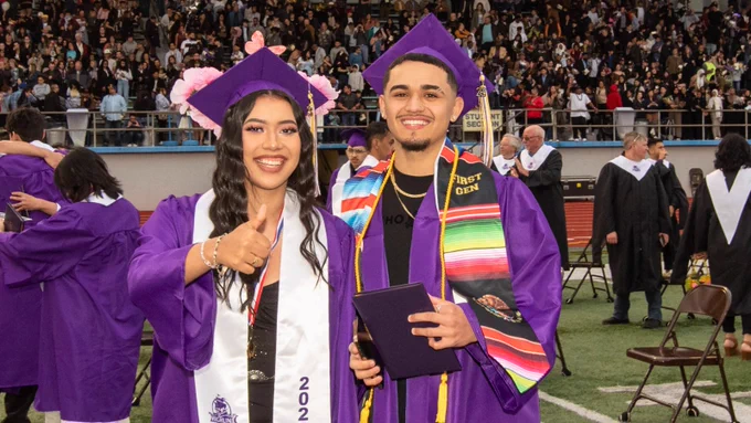 Two graduates give thumbs up