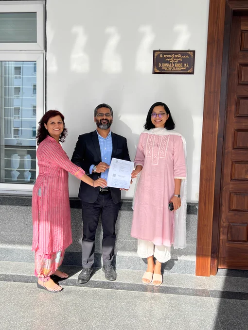 Photo of the Raspberry Pi Foundation and the Telangana Social Welfare Residential Educational Institutions Society. 3 people standing outside holding the partnership agreement together.