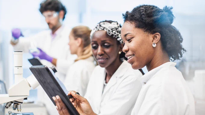 Two people working in a lab looking at a tablet