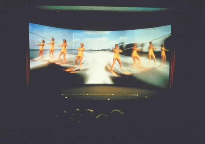 A photograph of This is Cinerama at Pictureville Cinema. It shows a curved screen with women on water skis.