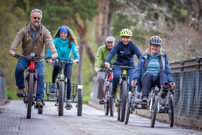 People riding bikes and adaptive bike in rural Scotland during a Cycling UK Rural Connections event.