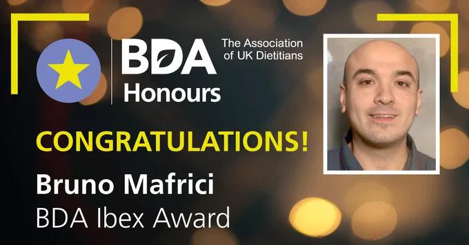 BDA Honours logo with the message: 'CONGRATULATIONS! Bruno Mafrici BDA Ibex.' Background is an abstract dark image with out of focus spotlights and a photograph of Bruno.
