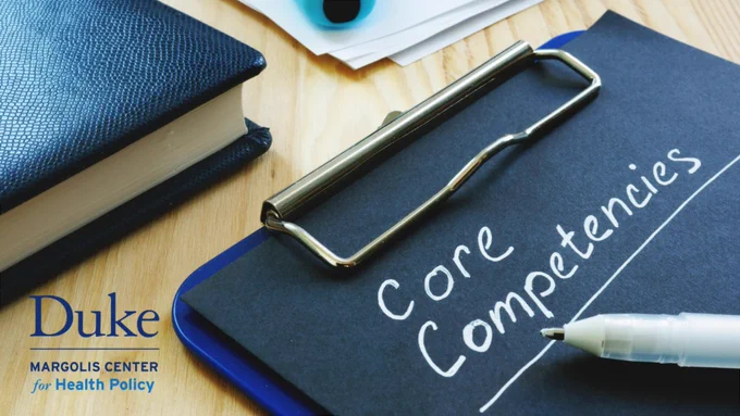 The graphic shows a photo of a clipboard with "Core Competencies" written on it using a white pen, also pictured. The clipboard sits at an angle on a wood-patterned desk, and the corner of a book and a stack of papers is also included. The Duke-Margolis Center for Health Policy logo sits in the bottom left corner of the image.