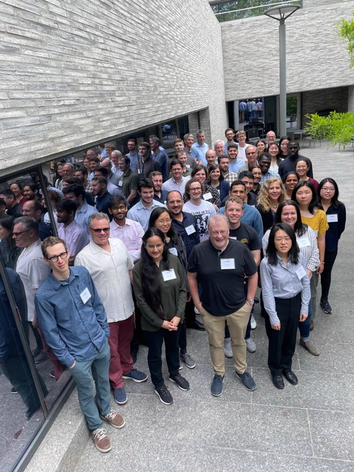 Full color image of large group standing in the courtyard at Andlinger Center during lunch break.