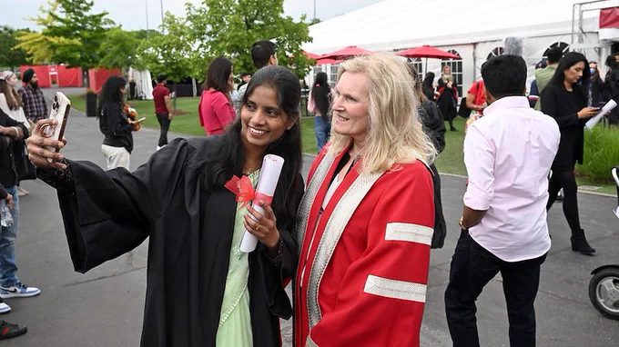 York President Rhonda Lenton poses with a School of Continuing Studies Graduate for a selfie following the graduation ceremony. 