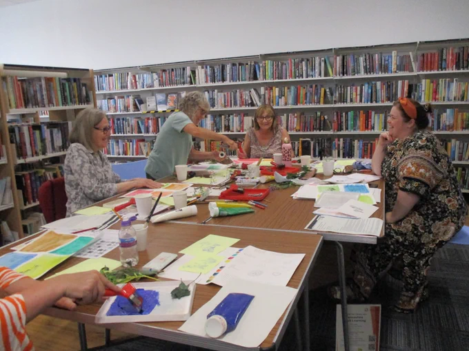 People talking, laughing enjoying making crafts.