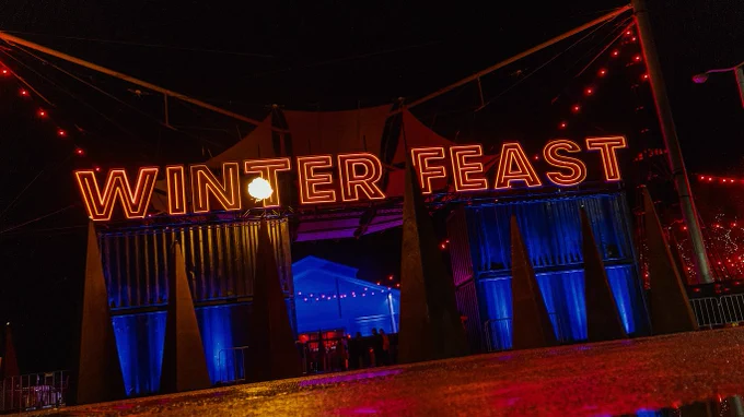 Dark Mofo's illuminated "Winter Feast" sign at the entrance to Princes Wharf 1. A fireball is shooting out of the top of one of the pyramid structures that decorate the Feast.