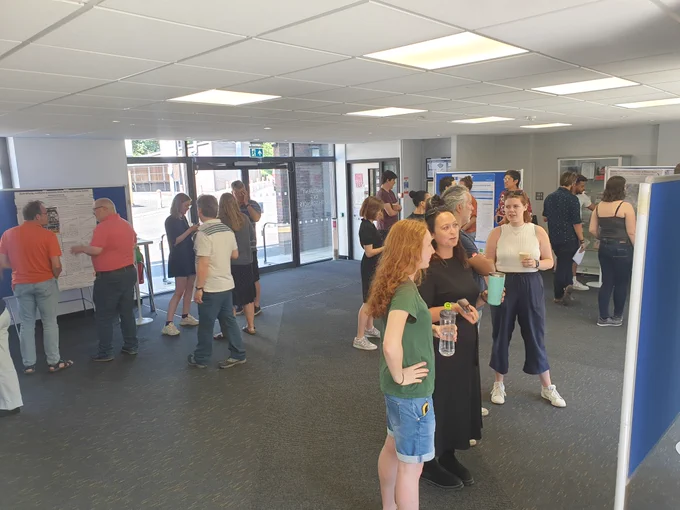 People talking in front of PGR posters
