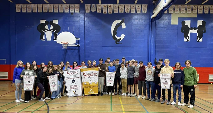 Student-athletes pictured with various banners, including the Gold Sports Stars banner.