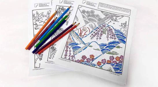 Coloring pages and color pencils arranged in a fan.