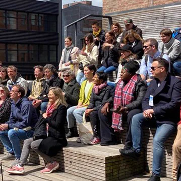 Diverse people sitting outside getting ready to be photographed.