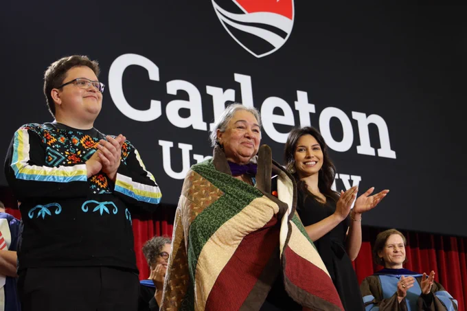 Barbara Dumont-Hill is presented with an honourary degree from Carleton University, involving a sacred Indigenous blanket ceremony. 