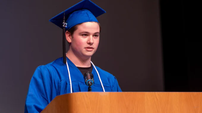 student speaking at podium during graduation