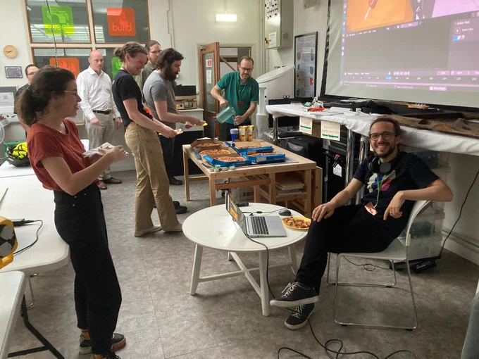 Nicola and other attendees chatting over pizza during a break.