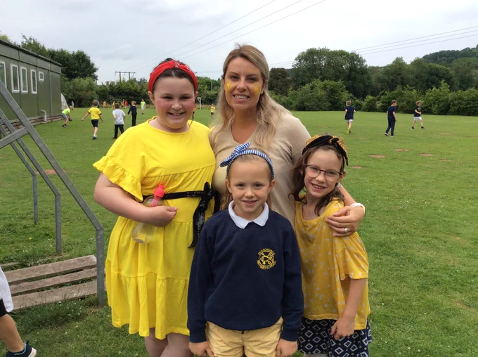 A photo of a woman with three young girls all wearing yellow for Ray For A Day.