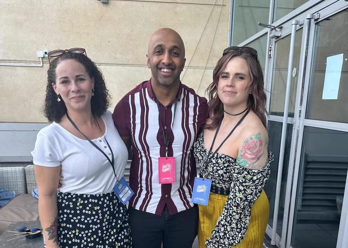 A man standing between two women