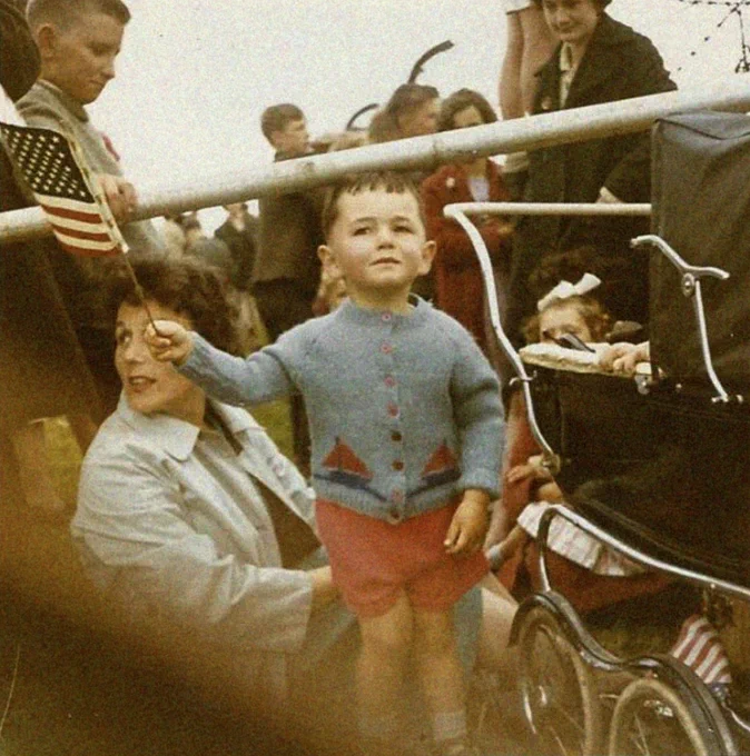 A young boy waves an American flag while awaiting the arrival of JFK at a GAA field in Wexford. 27th June 1963. Photo by Anna Kinsella.