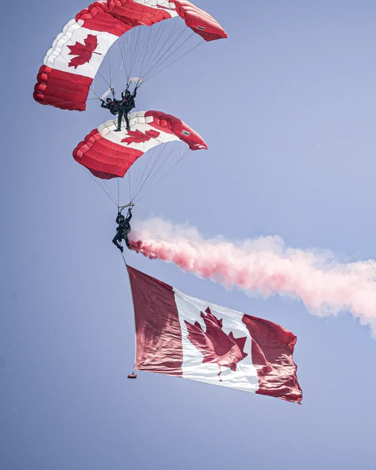 The Canadian Armed Forces parachute team, the SkyHawks, execute the Canadian T formation during a show in Quinte West, Ontario.