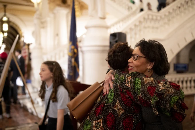 JoAnne Epps hugging a woman, smiling.