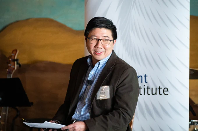 Dale Chu, President of DC Strategies, sits on a stage and moderates a discussion.