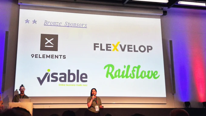 A foto of the stage of the rubyunconf. In the back theres the presentational canvas with all 4 Bronzesponsors presented in logos. The sponsors are: 9elements, Flexvelop, visable and railslove