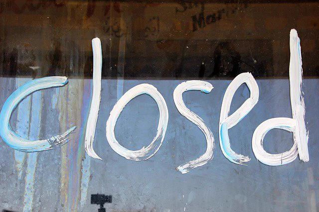 section of window with word 'closed' painted on